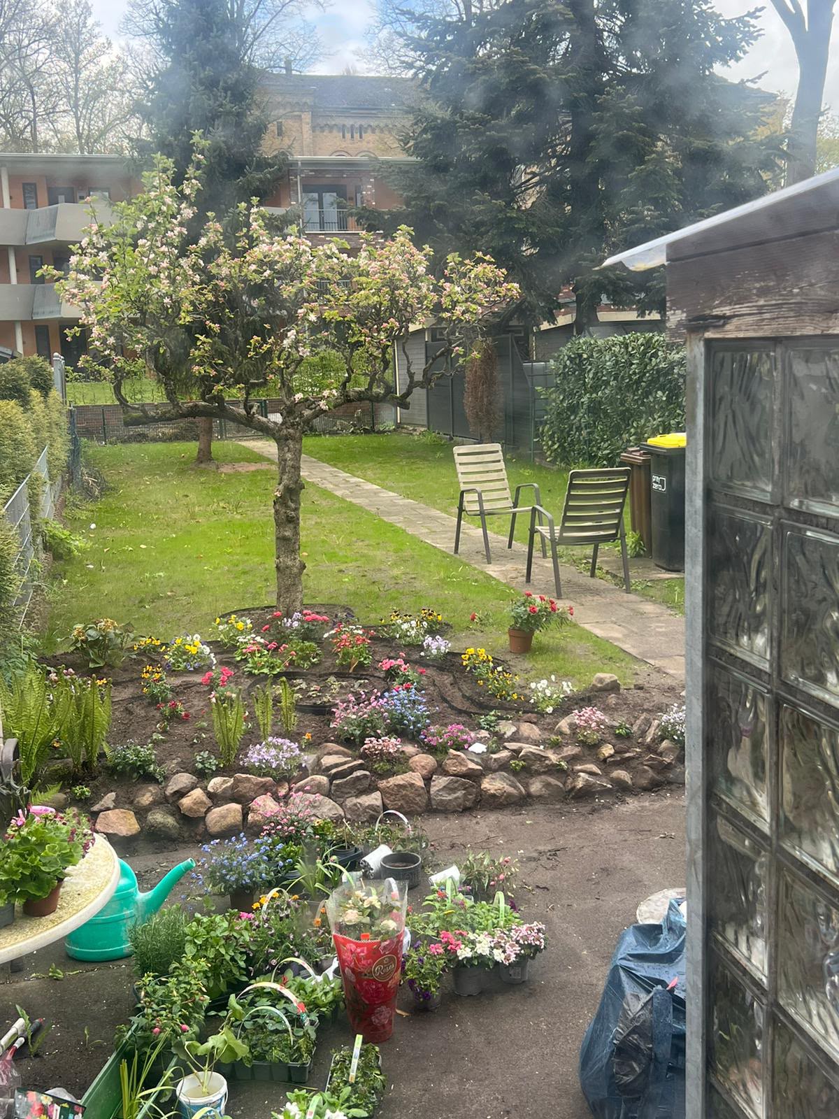 Gepflegter Garten mit Blütenbeeten und Apfelbäumen